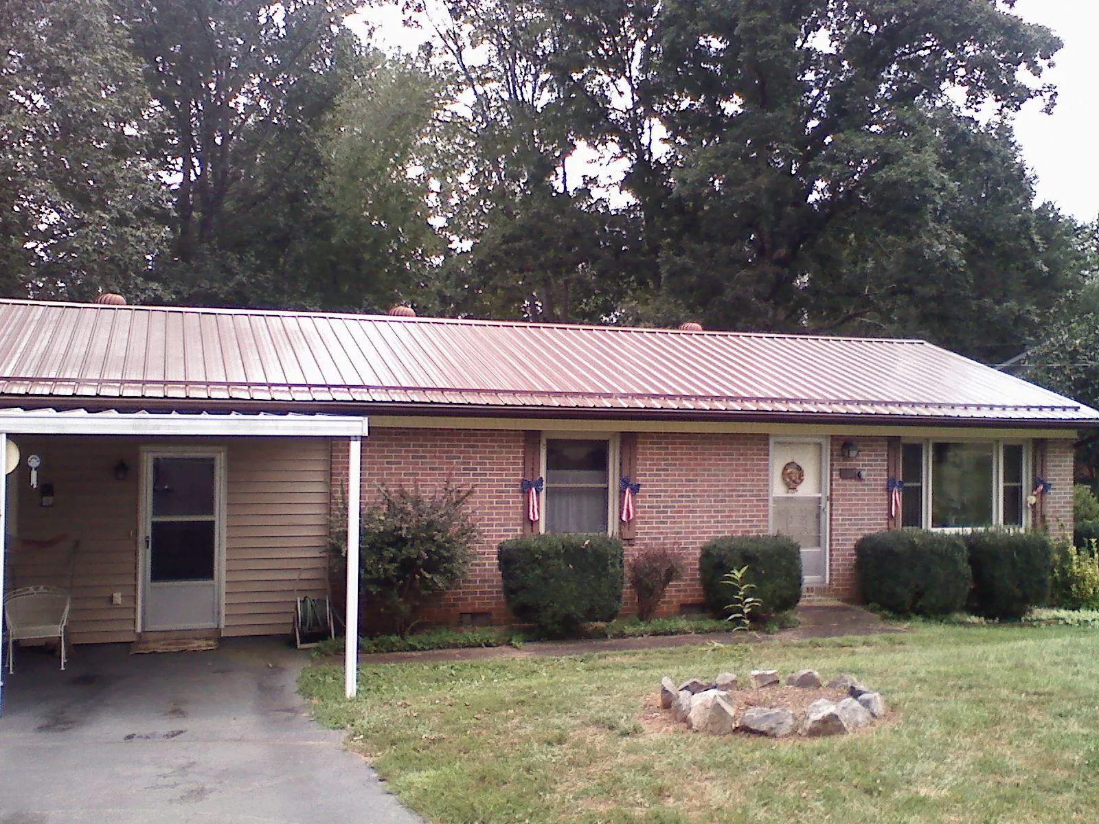 Bronze metal roof and carport on a brick ranch home — Roof Repair work by our crew in Skippack